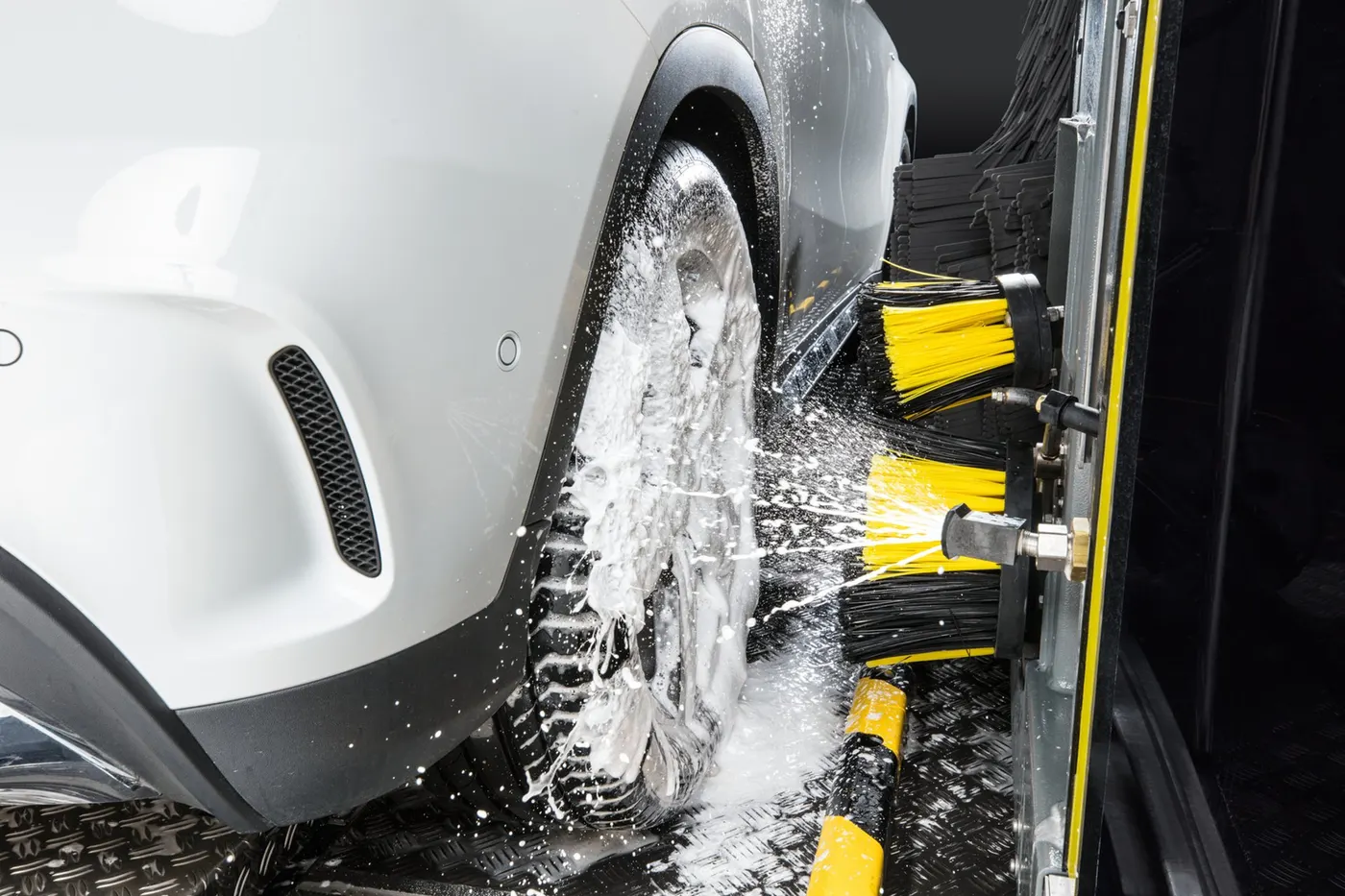 Fahrzeugrad unter Reinigungsschaum in der Waschanlage